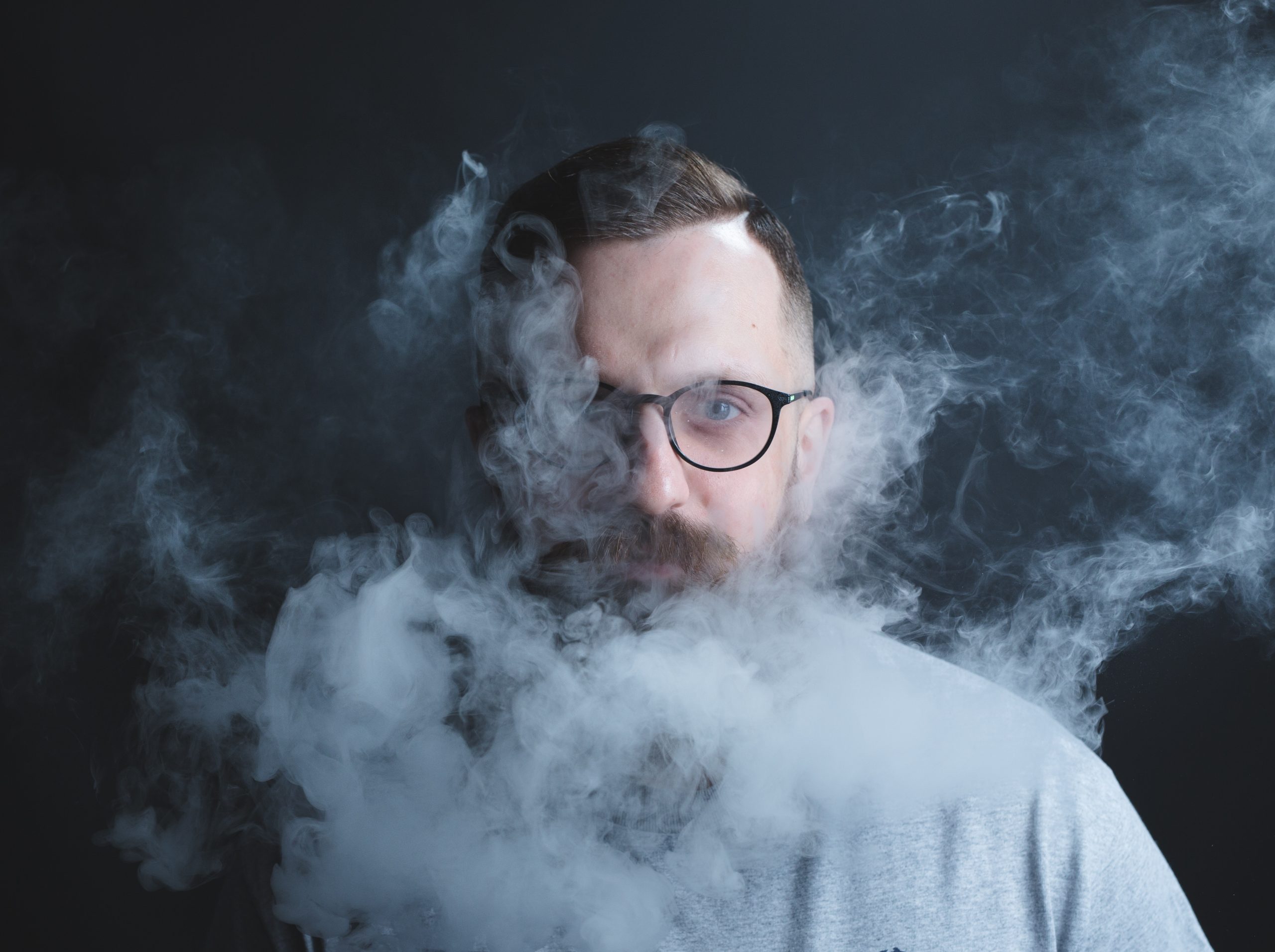 man exhaling vapors from a marijuana vaporizer