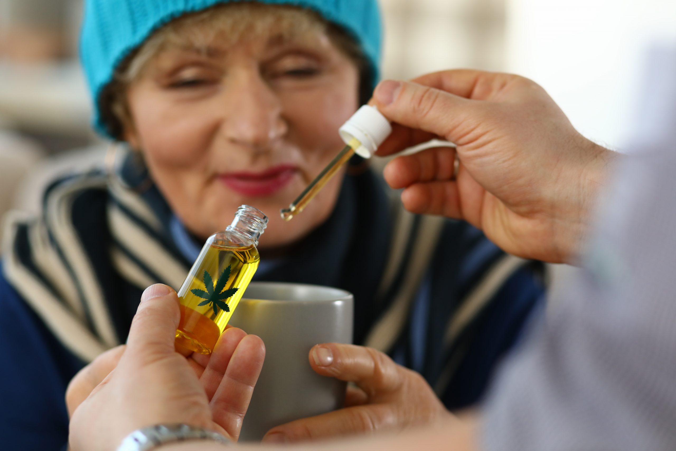 woman receiving drop of cannabis oil in her hot tea