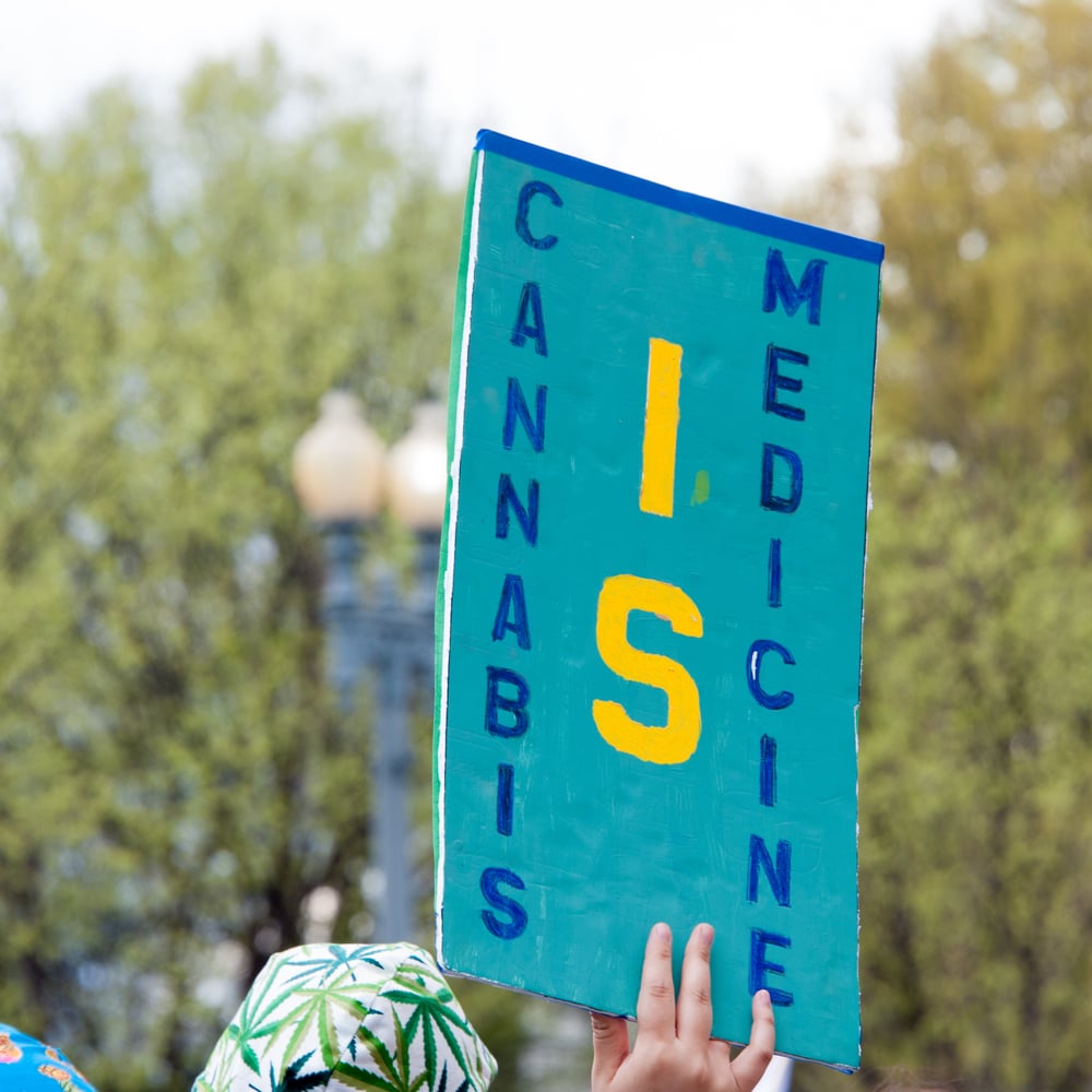 woman holding sign protesting for marijuana legalization