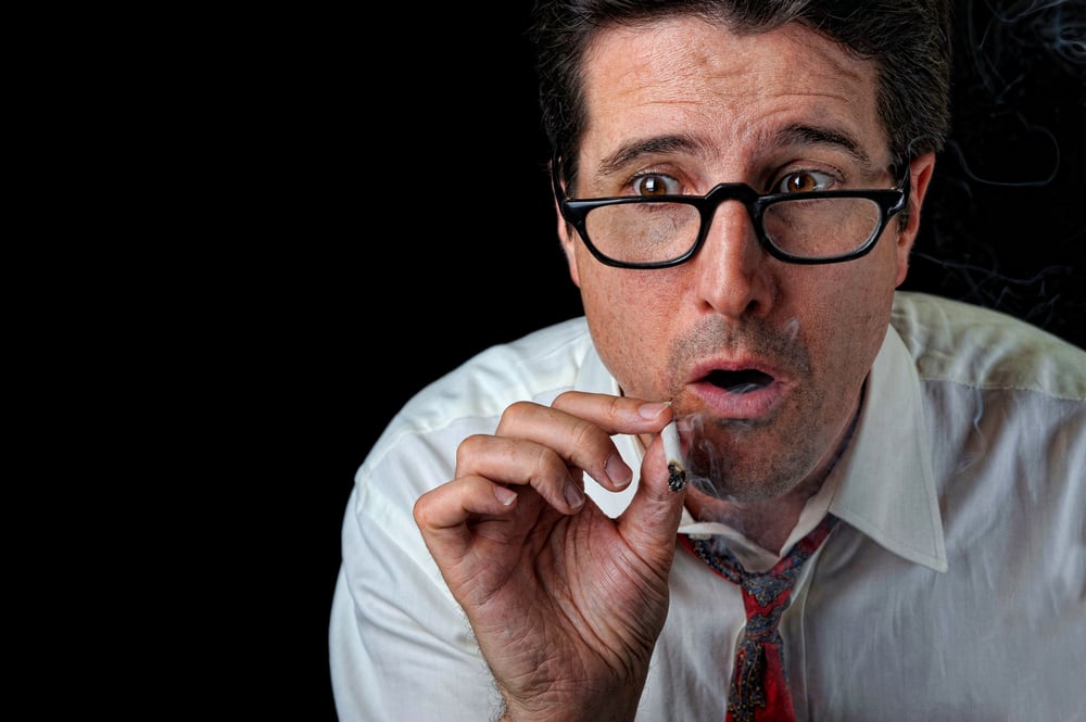 A businessman is surprised while taking a toke on his joint