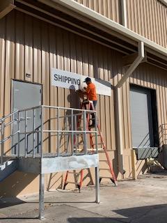 attaching the clovr sign to the exterior of the facility