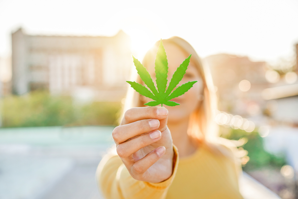 girl holding marijuana leaf