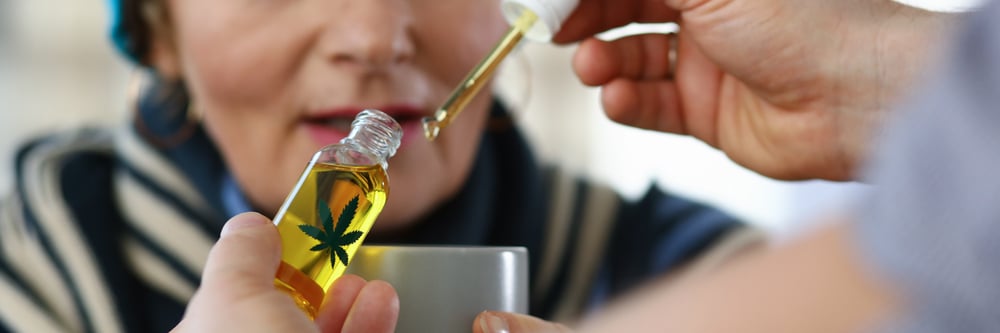 man adding cannabis oil to a womans hot tea