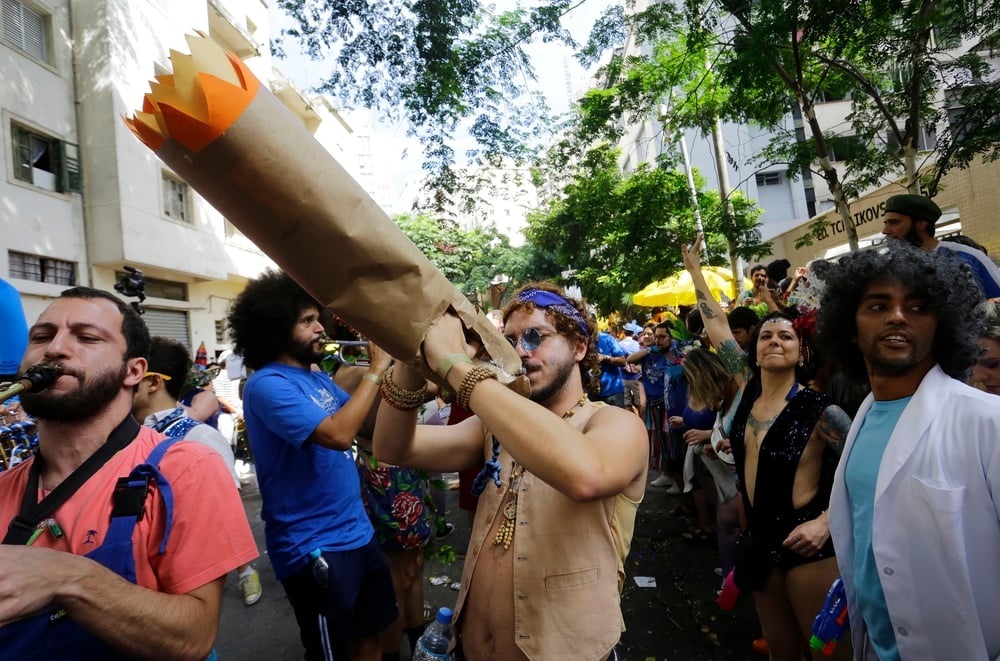 man at a parade smoking a giant joint