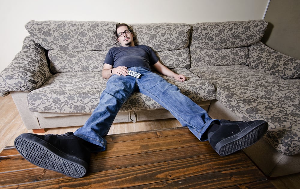 man falling asleep on a sofa