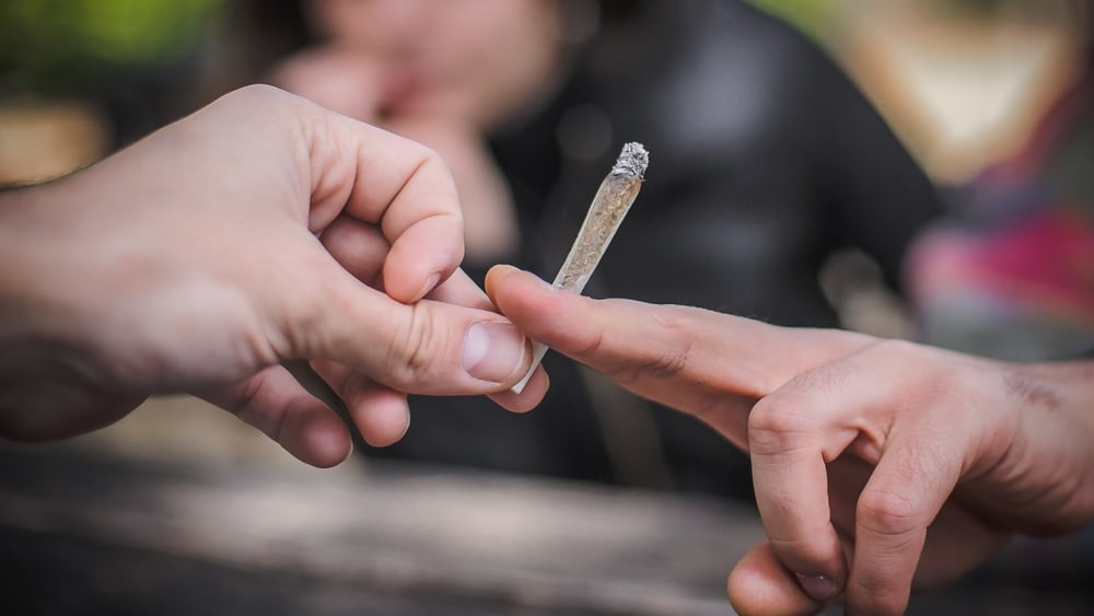 person passing marijuana joint