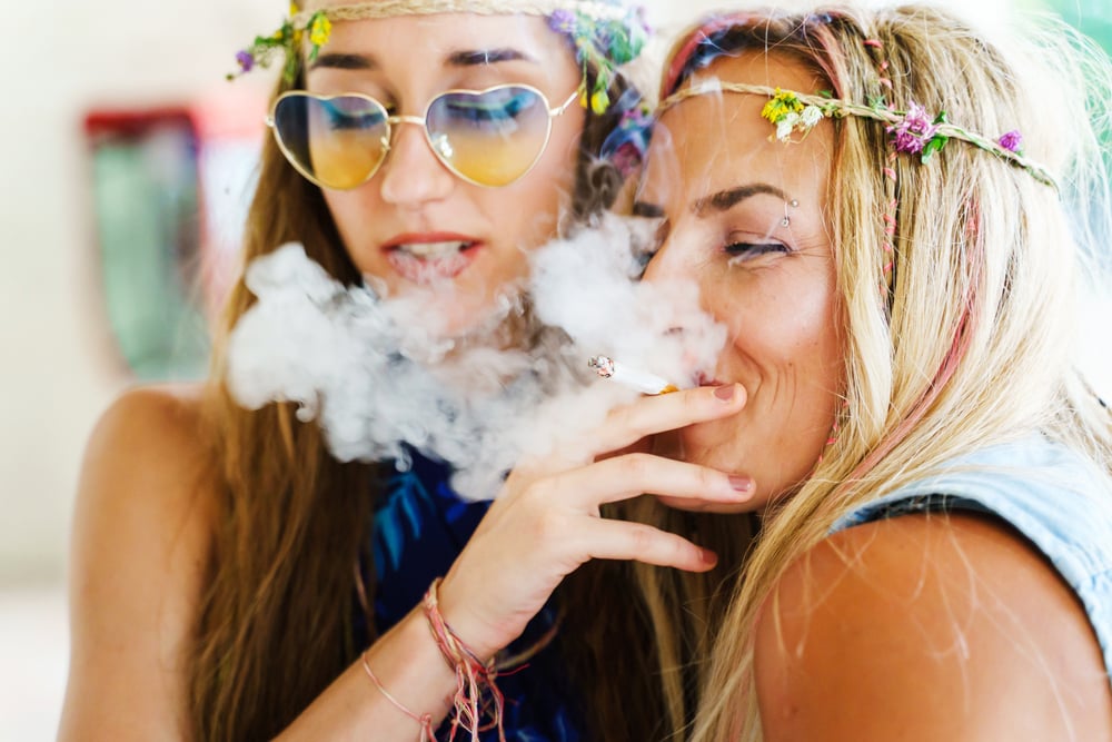 two female hippies smoking marijuana joints