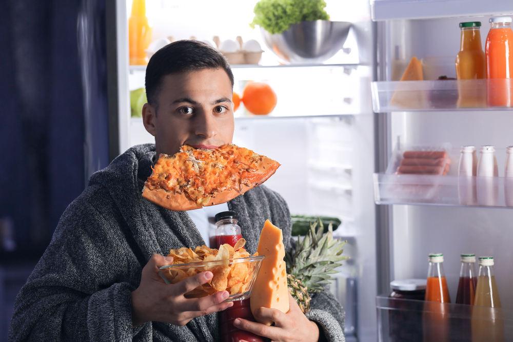 man eating food from the refrigerator