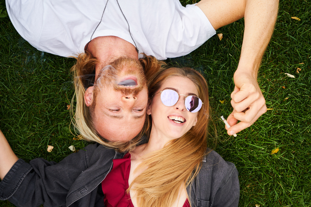 two people smoking marijuana outdoors