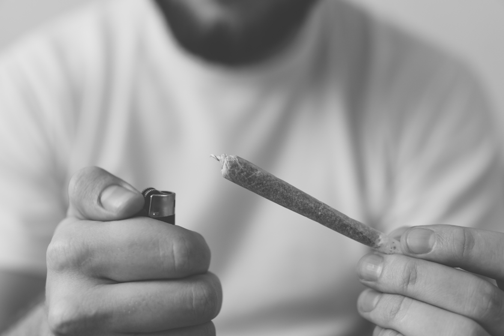 man lighting up a marijuana joint